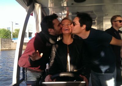 Two guys kissing a girl on a boat