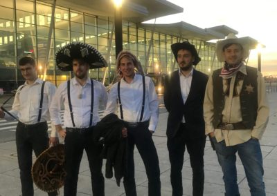 A group of guys dressed in hats waiting at the airport
